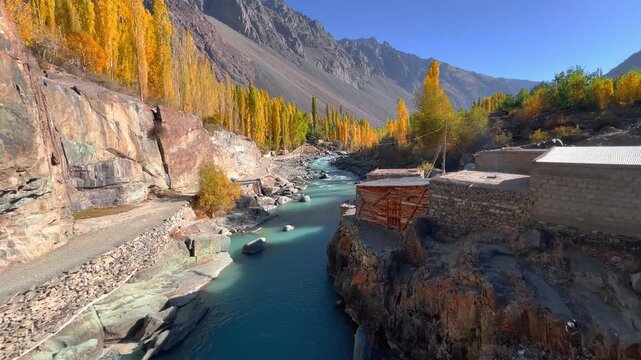 Cinematic 4K horizontal wide angle footage of Majestic Autumn Landscape of Gupis Valley with Winding Gilgit River and Golden Poplar Trees, Gilgit-Baltistan, Pakistan