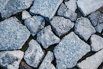 Broken asphalt creating abstract texture of destruction and decay on urban surface © Довидович Михаил