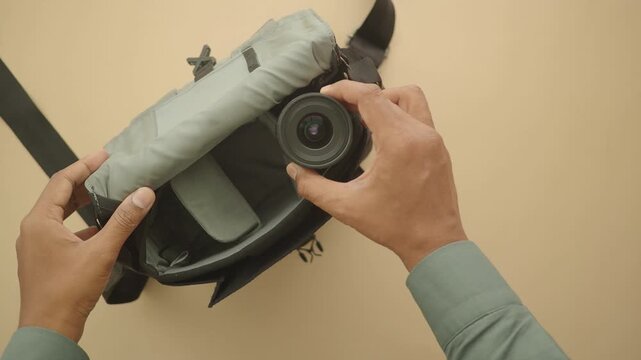 top view of putting camera and lens in a bag 