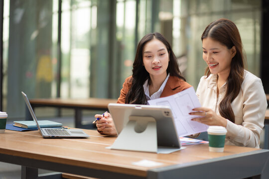 Two female coder or developer working overtime using a computer display in problem solving.