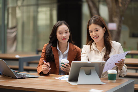 Two female coder or developer working overtime using a computer display in problem solving.