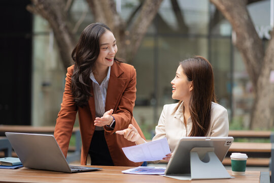Two female coder or developer working overtime using a computer display in problem solving.