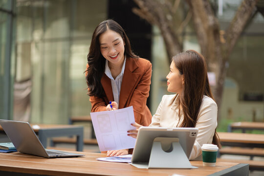 Two female coder or developer working overtime using a computer display in problem solving.