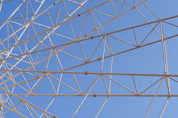 Naklejka premium Ferris Wheel Steel Structure Close-Up Low Angle Against Blue Sky