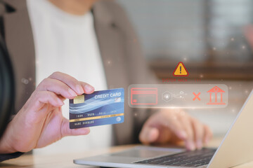 Business user holding credit card shopping online on laptop at home, digital warning icon show system hack risk, representing cyber fraud, data breach, and insecure online payment in modern ecommerce. © ART STOCK CREATIVE