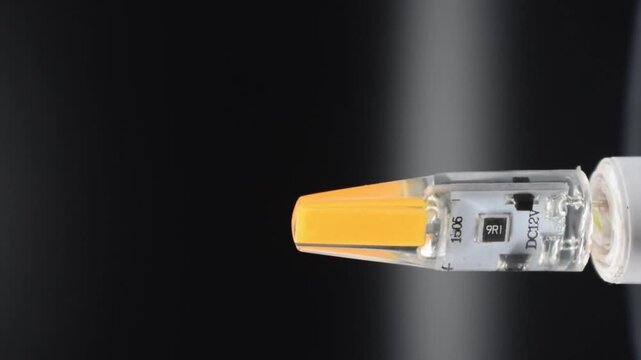 Macro shot of glowing orange LED diode on black background