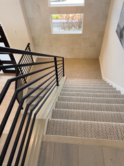 Carpeted Staircase with Black Metal Railings