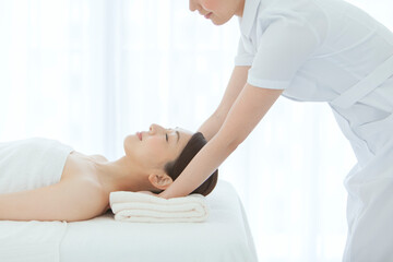 エステシャンとベッドに寝転ぶ女性