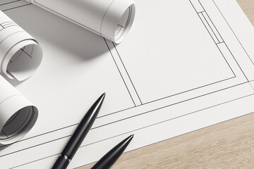 Architectural blueprints on modern desk. Contemporary workspace scene with rolled plans and pens...