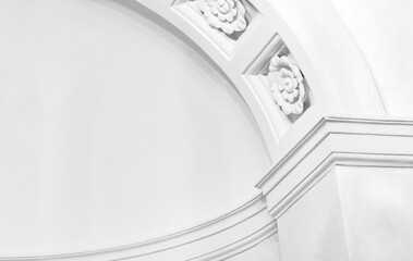 A refined white arch and decorative molding detail with floral rosettes. Abstract classic white architecture background photo © evannovostro