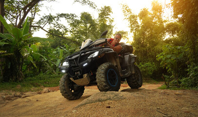 A man engages in extreme ATV riding on mountains in the evening © romaset