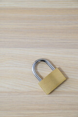 Naklejka premium Brass padlock on wooden background for security and privacy concept