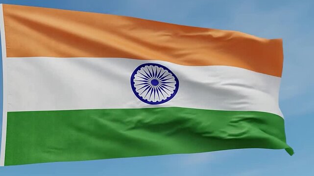 A tricolor flag with a circular emblem waves against a clear sky