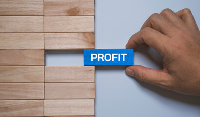 Fototapeta na wymiar Hand placing wooden block with word profit to complete gap in business blocks representing financial success, business growth, revenue increase, strategic planning and profitability concept.