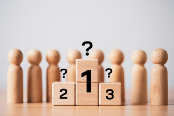 Wooden blocks with ranking numbers and question marks among group figures representing leadership...