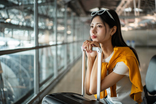 Unhappy young woman traveler disappointed with flight delay or cancelation while waiting at airport terminal, female tourist upset after receiving bad news when sitting at airline lounge.