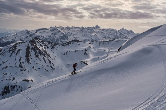  A ski tourer ascends the beautiful Swiss mountains. Ski mountaineering in winter. Climbing Mount Hochfinsler. High quality photo