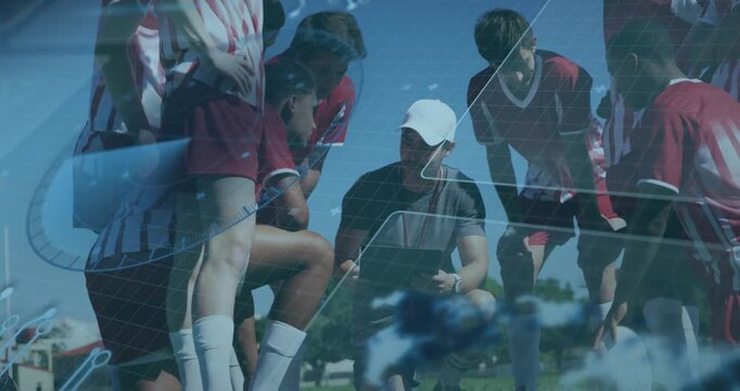 Coach kneeling turning tablet, explaining soccer tactics, players leaning in as diagrams floating
