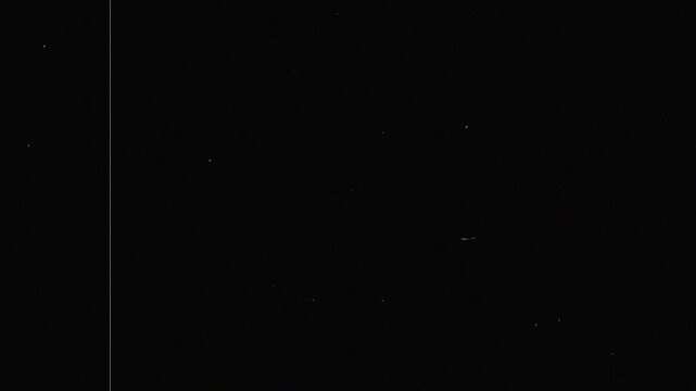 Old film tape defects featuring noise, analog distortion, and film scratches on black background 4K video resolution.