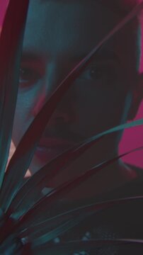 Shadowed figure among lush foliage, Enigmatic figure concealed behind vibrant plant leaves with neon highlights