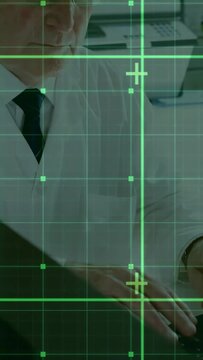 Vertical video: Senior exec typing causing green grid mapping docs in business office while reading