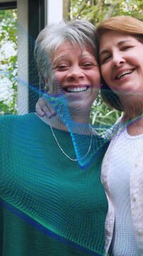 Vertical video: Senior woman posing friend coming and hugging teal overlay crossing faces for tech