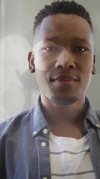 Vertical video: Man leaning in while left light causing bokeh overlays entering left for marketing