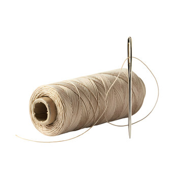 Beige sewing thread spool standing next to a sharp metal needle on a white background