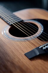 Obraz premium Close-up of Acoustic Guitar Sound Hole and Strings on a Wooden Body