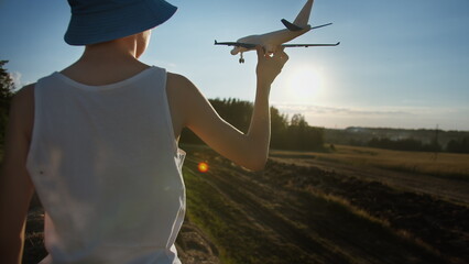 funny boy in a blue hat playing with airplane near wheat field, boy dreams of being a pilot, have fun and enjoy © vla