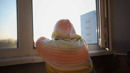 woman in a sweater stands on the balcony and enjoys the sunrise, sun glare, have fun and enjoy © vla