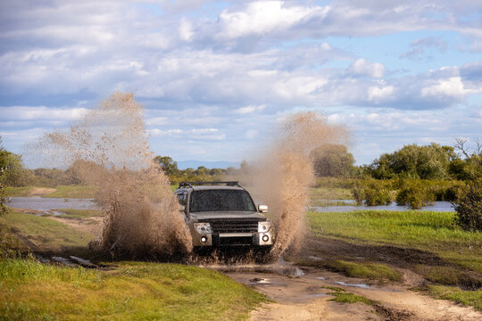 Japanese SUXV moving by a puddle making a lot of splashes