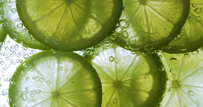 Lime Slices falling deeply under water. Shot on super slow motion camera 1000 fps.