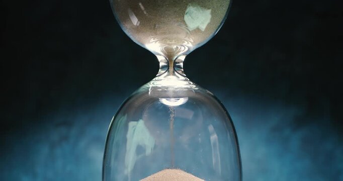 Hourglass with sand flowing upward symbolizing reversed time. Concept of turning back time.
