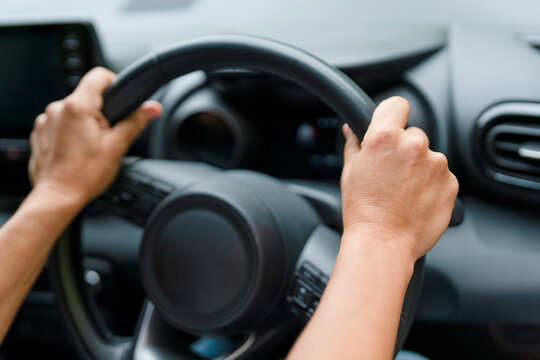 Driving a car with both hands on the steering wheel while focusing on the road ahead