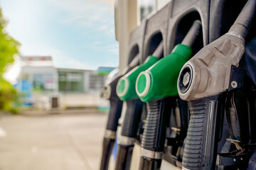 Fuel pumps at a gas station with a view of the store and a clear sky on a sunny day © Iryna