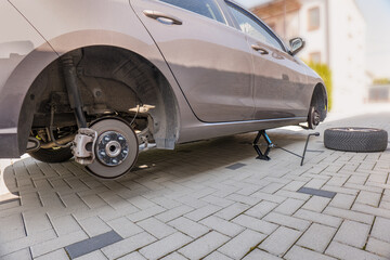 Lifted car with a scissor jack. Front and back wheels exchange