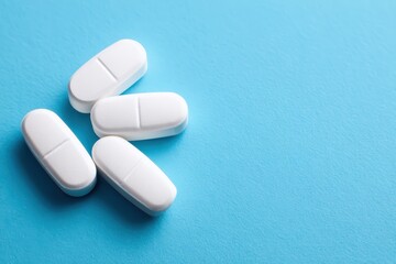 White film coated caplets arranged on clinical blue paper background, pharmaceutical branding concept. Modern medication product presentation healthcare advertising and medical treatment theme.