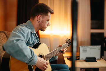 Obraz premium Musician composing music playing acoustic guitar at home