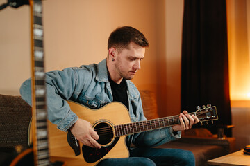 Obraz premium Musician composing music at home playing acoustic guitar