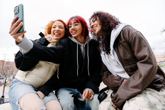 Young women capturing urban friendship moments