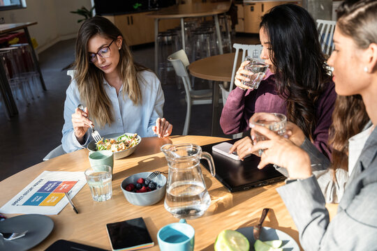 Businesswomen sharing a meal and ideas in an office setting