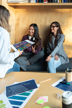 Businesswomen discussing creative ideas in modern office