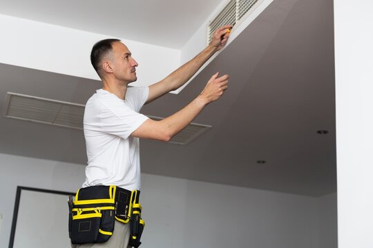  HVAC Technician Worker Testing Newly Installed Ventilation System. Commercial Heating, Cooling and Air Ventilation Systems.