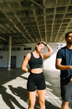 Two athletes stretching in an urban indoor setting