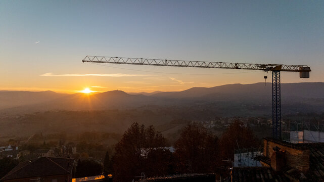 Construction crane during sunrise in Cingoli, Italy