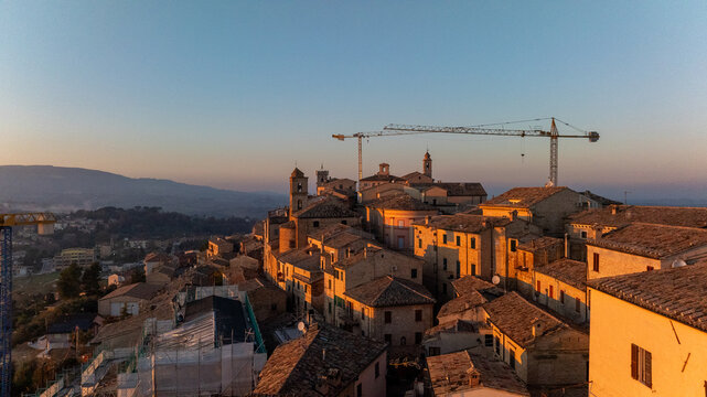 Aerial view of Cingoli at sunset with cranes visible