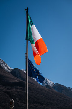 Italian and eu flags waving in a mountainous landscape