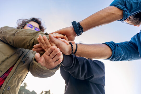 Friends unite in a supportive gesture by the sea