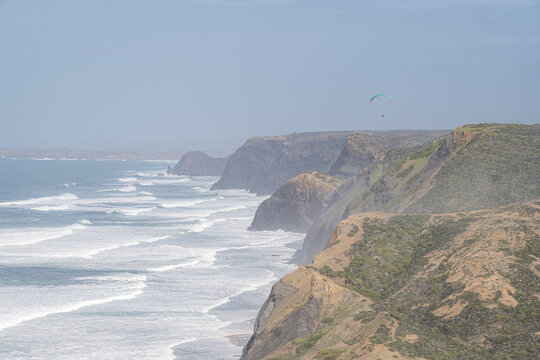 Paraglider over Cordoama cliffs on a cloudy day